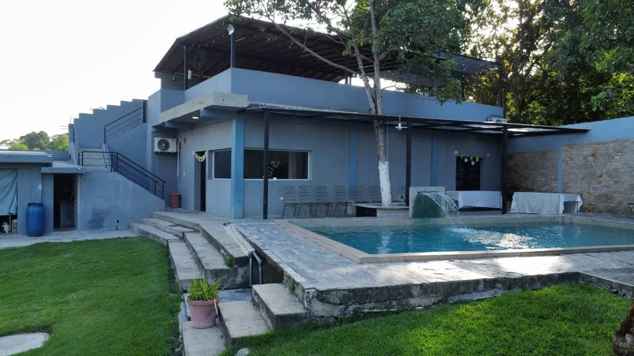 Fachada de la casa de La Huerta junto a la piscina y el jardín